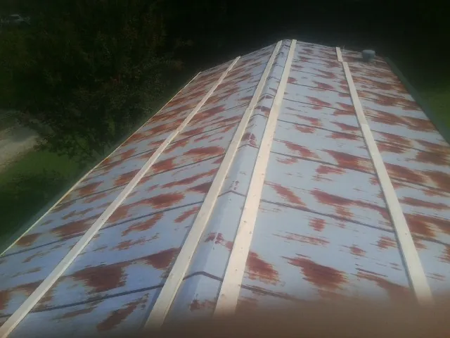 Rusted metal roof panels with new wood purlins before replacement — Storm Damage Roof Repair in Clayton by Roofing Brothers